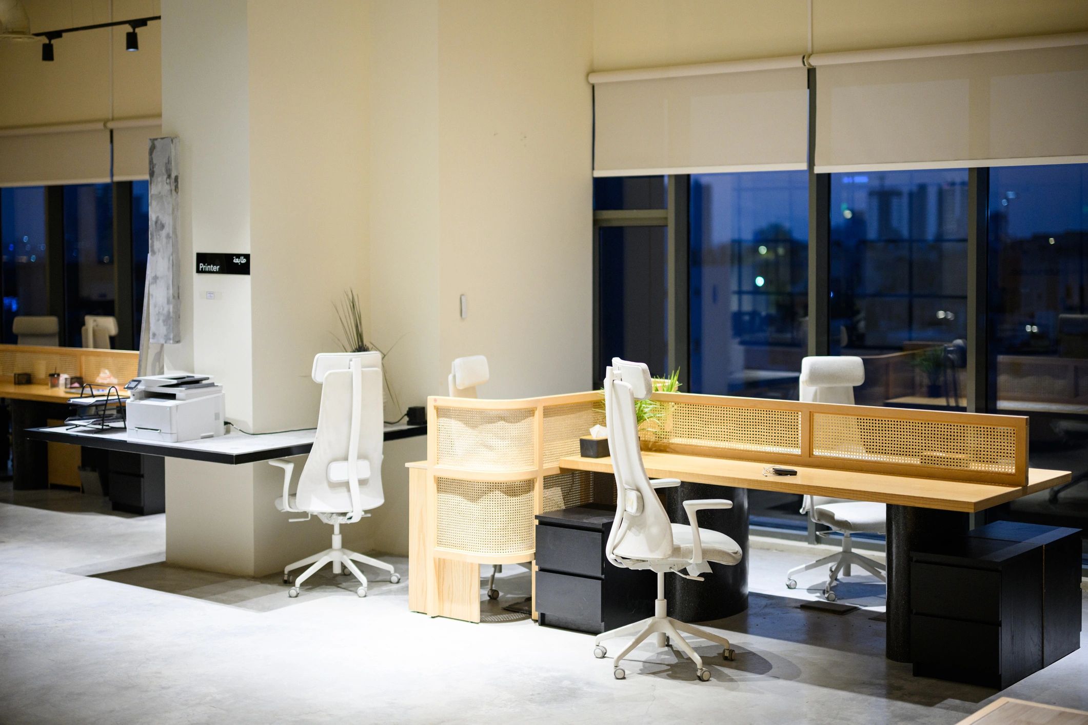 Modern dark coworking office with desks and city lights